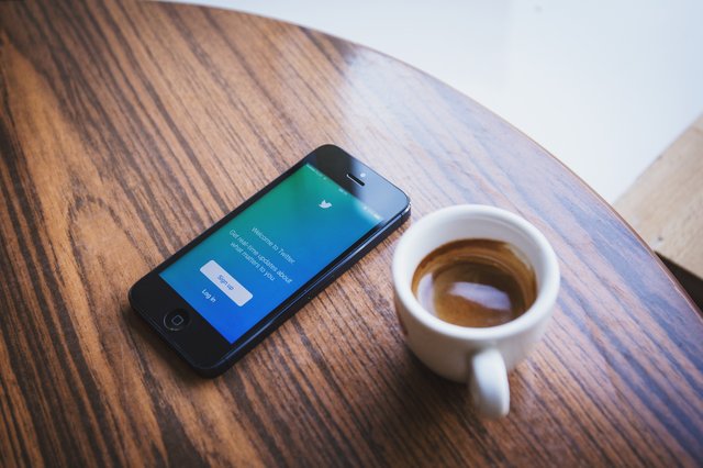 coffee cup and mobile phone sitting on a table.