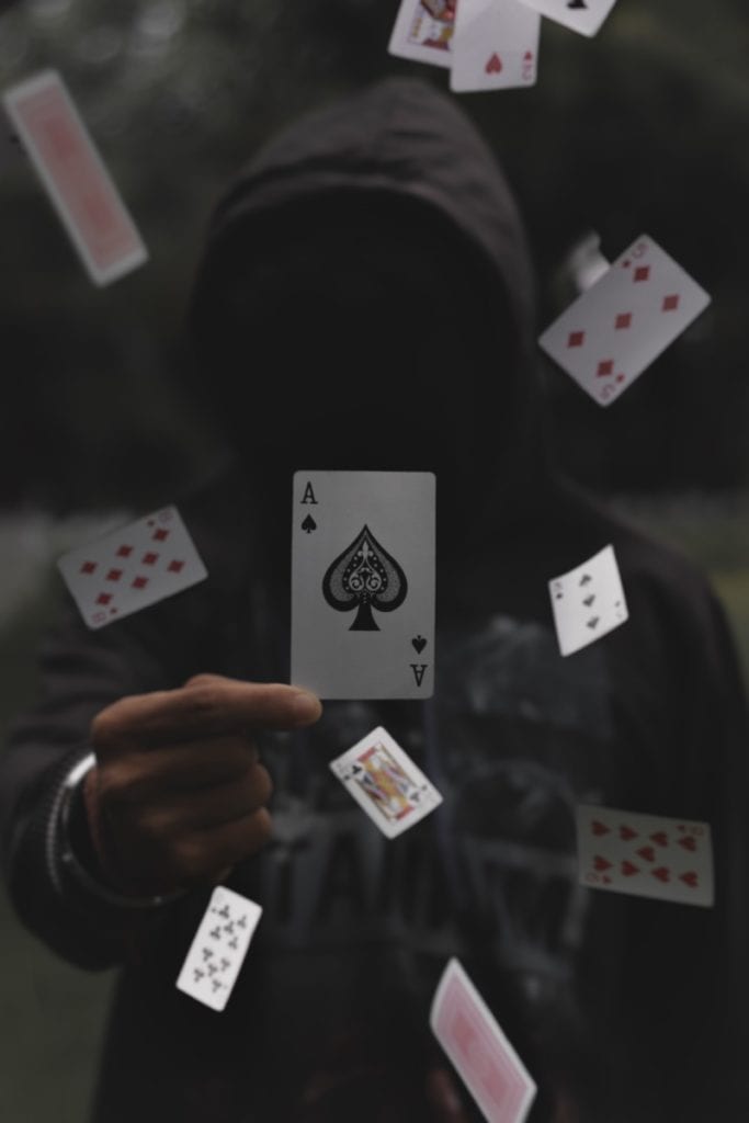 anonymous holding up an ace of spades