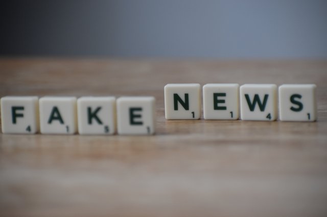 fake news spelled out using scrabble pieces